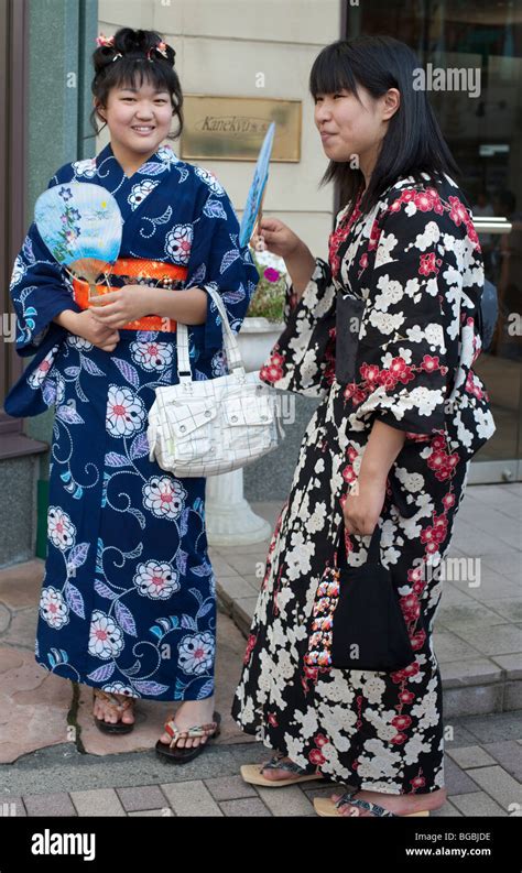 Girls In Traditional Summer Dress Or Yukata With Paper Fans At A
