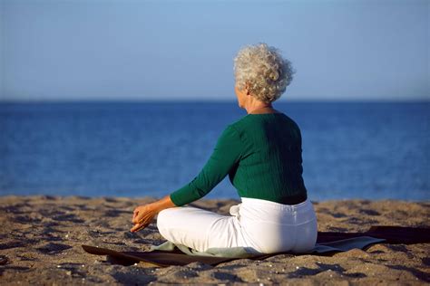 Senior Woman Doing Yoga Meditation Beach