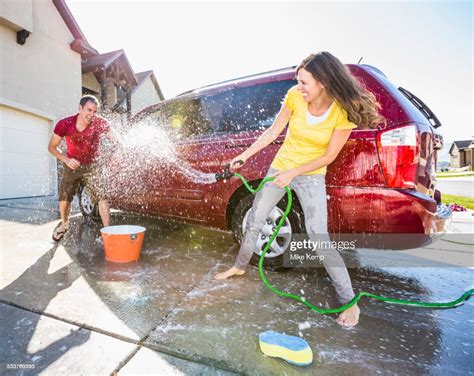Caucasian Couple Playing While Washing Car In Driveway Photo Getty Images
