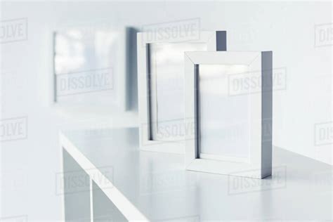 Close Up View Of Empty Photo Frames Standing On Bookshelf Stock Photo