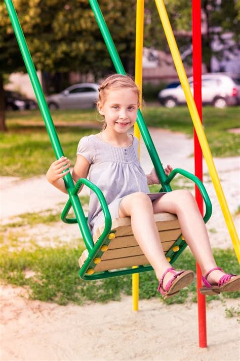 Beautiful Little Girl On A Swings Outdoor In The Playground Stock Image