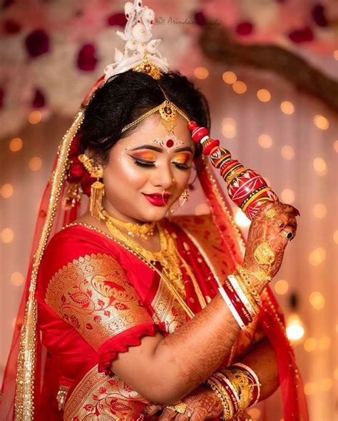 A Woman Dressed In Red And Gold With Makeup