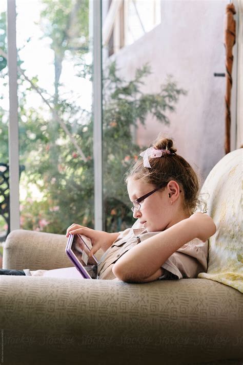 Tween Girl With Ipad On Sofa By Stocksy Contributor Gillian Vann