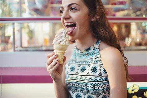 A Teenage Girl Eating Ice Cream At A Carnival By Stocksy Contributor