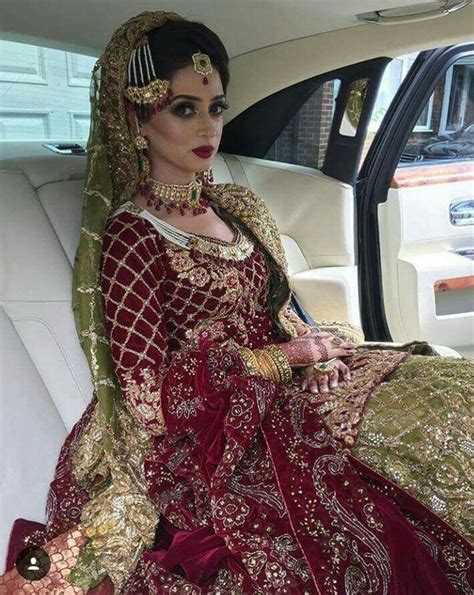 A Woman Sitting In The Back Of A Car Wearing A Red And Gold Bridal Gown