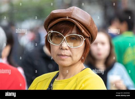 candid portrait of mature taiwanese woman of chinese ethnicity in the city looking cool wearing