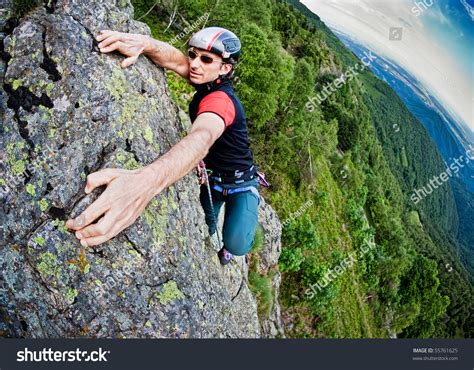 Young White Man Climbing A Steep Wall In Mountain Rock