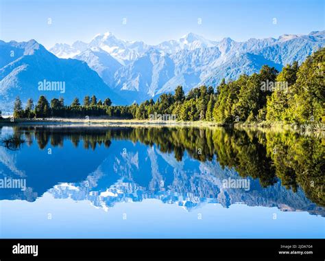 Perfect Reflection In Lake Matheson Surrounded By Beautiful Natural