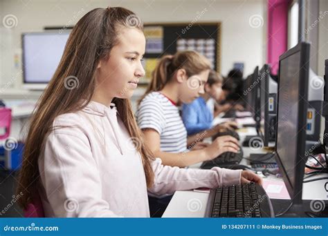 Line Of High School Students Working At Screens In Computer Class Stock