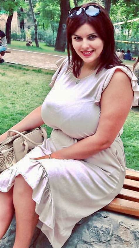 A Woman Sitting On Top Of A Wooden Bench