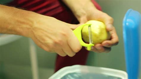 Man Holding And Peeling Potato By Using Peeler Stock Footage Video