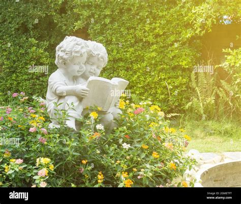 Sculpture Of Boy And Girl Reading The Book In Public Garden Stock Photo