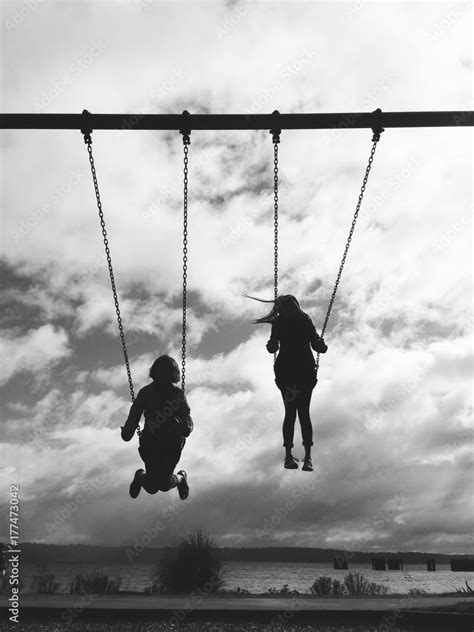 Silhouette Of Two Girls On Swing Stock Photo Adobe Stock