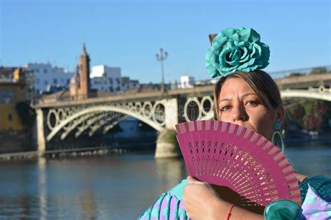 the spanish girl near the river wearing a flamenco dress and seduces with a purple fan stock