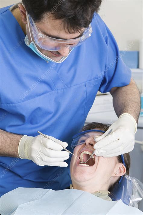 Dentist And Carrying Out Dental Treatment On A Patient Stock Image