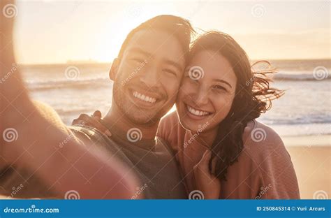 Portrait Of A Young Diverse Biracial Couple Taking A Selfie At The Beach And Having Fun Outside
