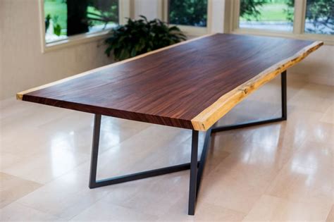 A Wooden Table Sitting On Top Of A Hard Wood Floor Next To Two Windows