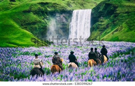 Tourists Ride Horses At The Majestic Skogafoss Waterfall In Countryside