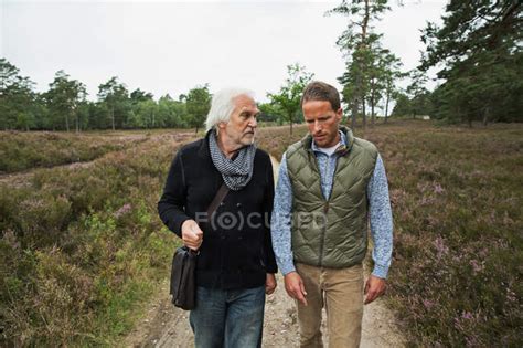 Father And Adult Son Walking On Dirt Track — Togetherness Adult