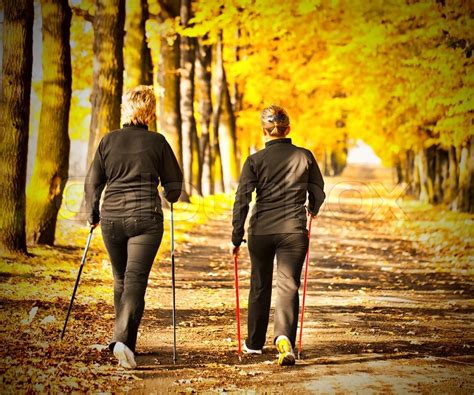 Two Women In The Park In The Autumn Nordic Walking Stock Photo