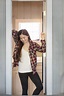 Woman standing in doorway at home stock photo