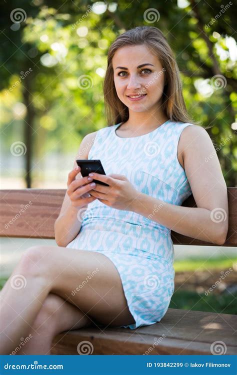 Girl Sitting On A Bench And Using Phone In Park Stock Image Image Of