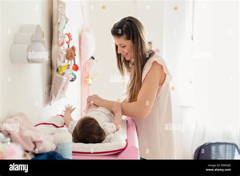 Mother Changing Baby Girls Diaper On Changing Table Stock Photo Alamy