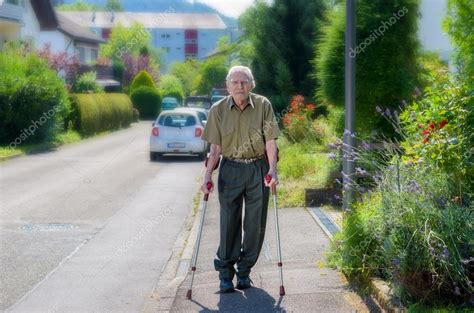 Elderly Man Walking On Crutches On A Sidewalk — Stock Photo © Info