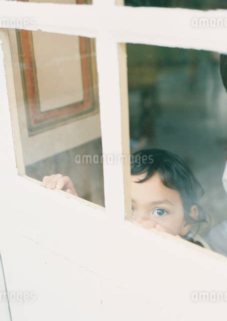 ドアごしに外をのぞく女の子の写真素材 Fyi04038884 ストックフォトのamanaimages Plus