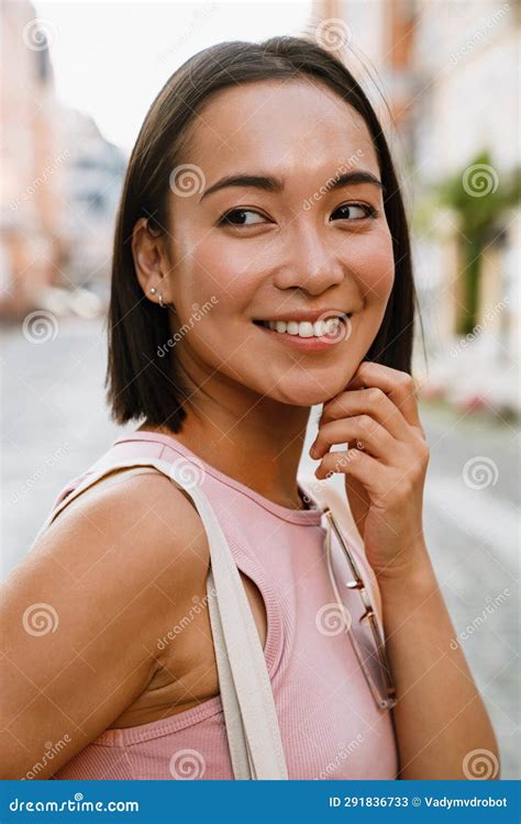 brunette asian woman smiling while walking on city street stock image image of smiling