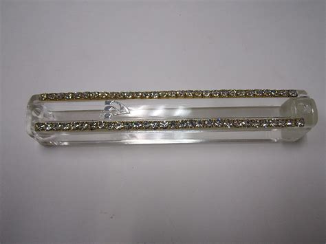 Clear Plastic Mezuzah Holder With A Row Of Diamond Like