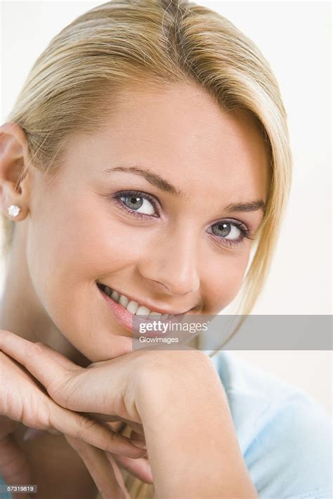 Portrait Of A Young Woman Smiling With Her Hand On Her Chin High Res