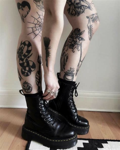a person with tattoos on their legs and boots