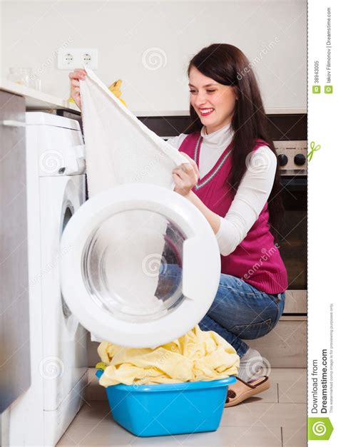 Woman Looking White Clothes Near Washing Machine Stock
