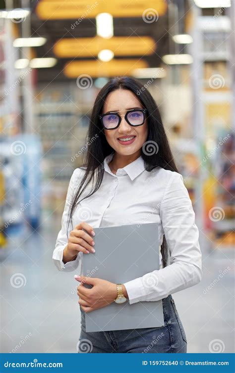 Young Attractive Positive Girl Seller On The Background Of The Shopping