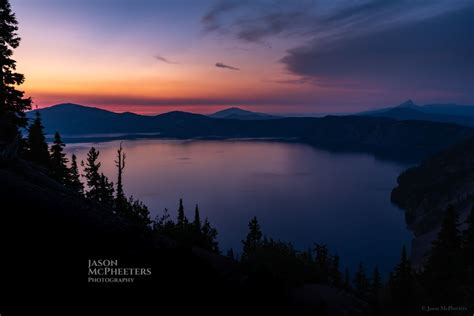 View Of Crater Lake At Sunset With Dark Purple And Orange Skies Crater