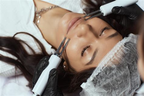Premium Photo Cosmetology Beautiful Woman At Spa Clinic Receiving Stimulating Electric Facial