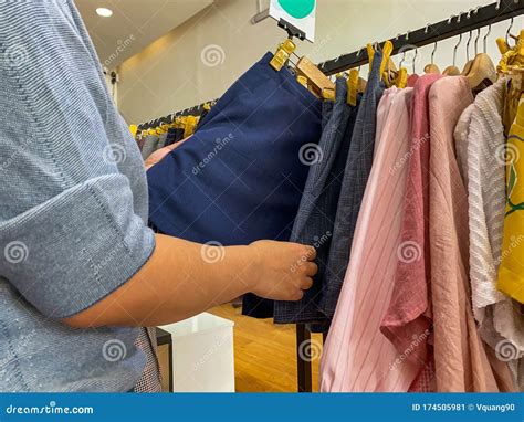 Woman Hands Choosing Skirt While Shopping At Clothing Store Stock Image