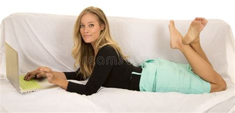Woman In Green Skirt Laying With Laptop Legs Up Smile Stock Image