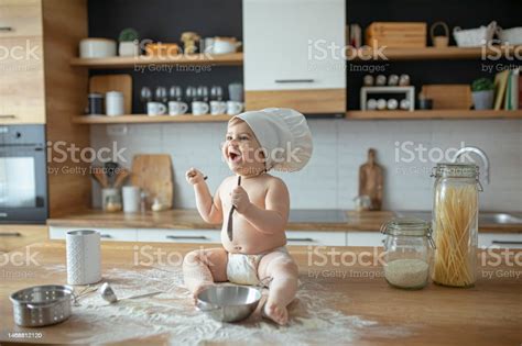 Anak Lakilaki Bermain Dengan Tepung Dan Duduk Di Meja Dapur Foto Stok