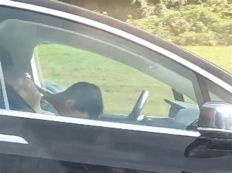 tesla driver filmed ‘sleeping behind the wheel of his car