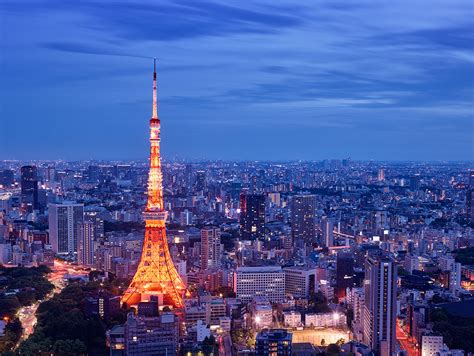 tokyo tower at dusk night lights blue sky city below from above long exposure lights orange