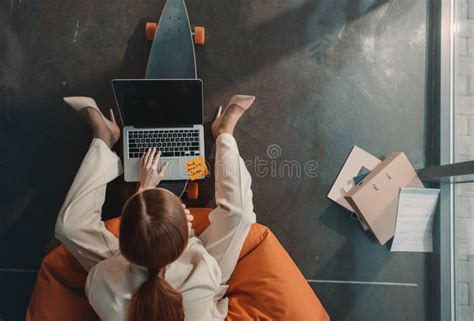 Young Businesswoman Sitting In Bean Bag Chair And Using Laptop Stock