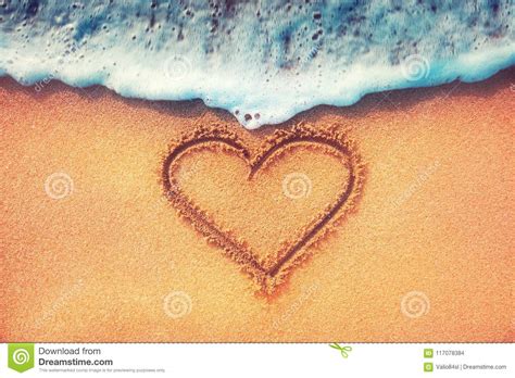 Love Heart On A Sand Of Beach With Wave On Background Stock Photo
