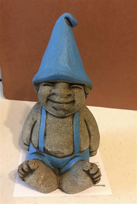 A Statue Of A Gnome Sitting On Top Of A Table