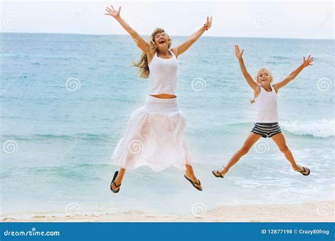 Madre E Hija Que Saltan En La Playa Foto De Archivo Imagen De Cubo