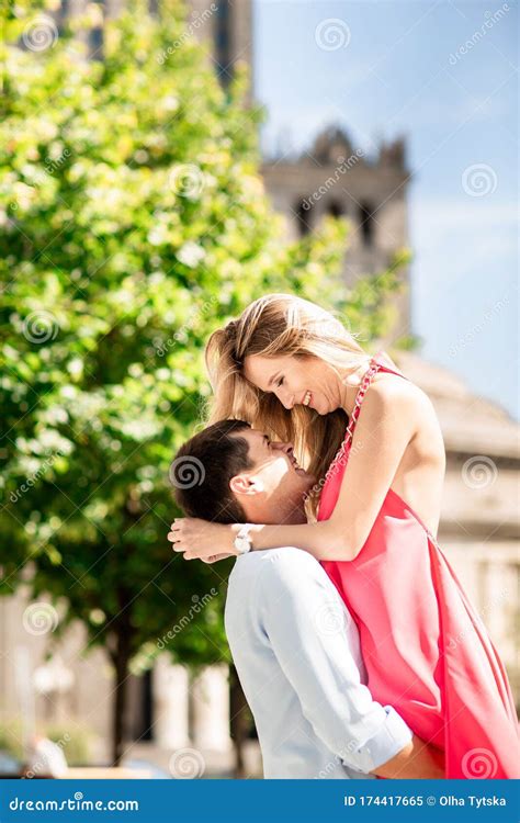 blonde woman in red dress having fun with her man a man holding a woman in his arms love story