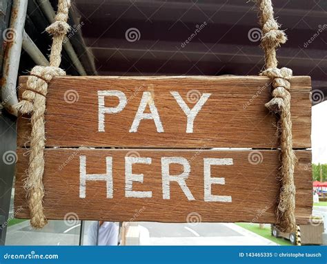 Vintage Wooden Sign To Indicate Cashier Location. Pay Here Written on