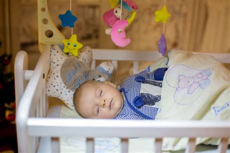 Adorable Newborn Baby Boy Sleeping In Crib At Night Stock Image