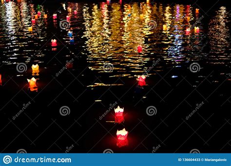 Candle Lanterns Floating On A River Among Colorful Reflections During